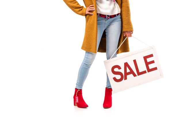 cropped view of girl in autumn outfit holding board with sale sign, isolated on white - Valokuva, kuva