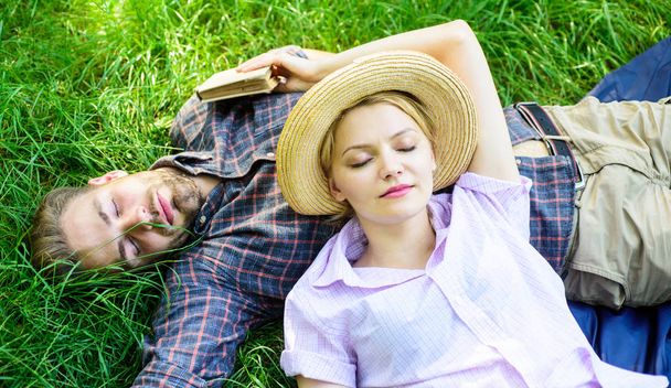Nature fills them with tranquility and peace. Man unshaven and girl lay on grass meadow. Guy and girl dreamy sleepy enjoy tranquility nature. Couple in love having nap outdoors. Time for nap - Photo, image