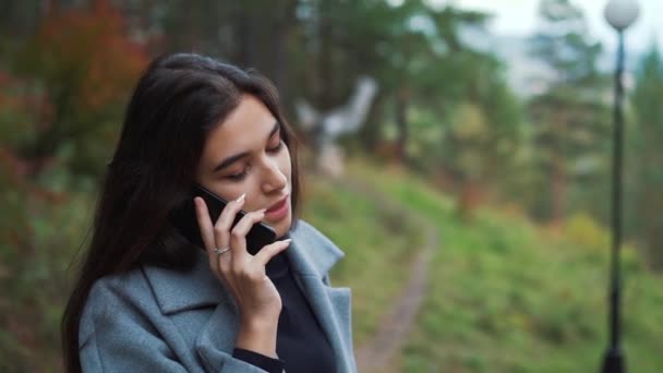 Nő beszél egy mozgatható sejt telefon Park közelről - Felvétel, videó