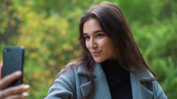 Boldog fiatal nő küldött sms, SMS a parkban - Felvétel, videó