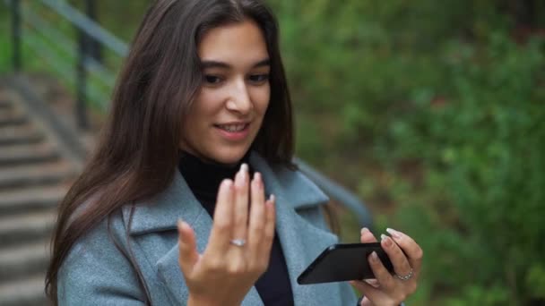 Happy young woman sending sms, texting in the park - Filmagem, Vídeo