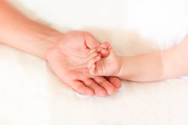 Vater hält die Hand seines neugeborenen Sohnes, flach dof. tust, support, security und care concept - Foto, Bild