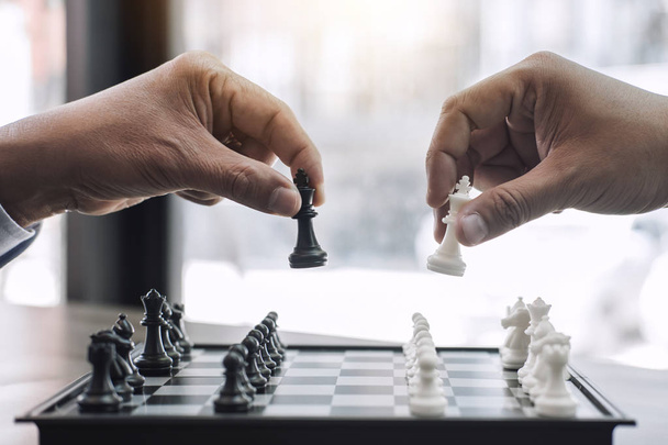 Manos de colegas de negocios confiados jugando ajedrez al análisis de desarrollo nuevo plan de estrategia, líder y concepto de trabajo en equipo para ganar y tener éxito
. - Foto, imagen