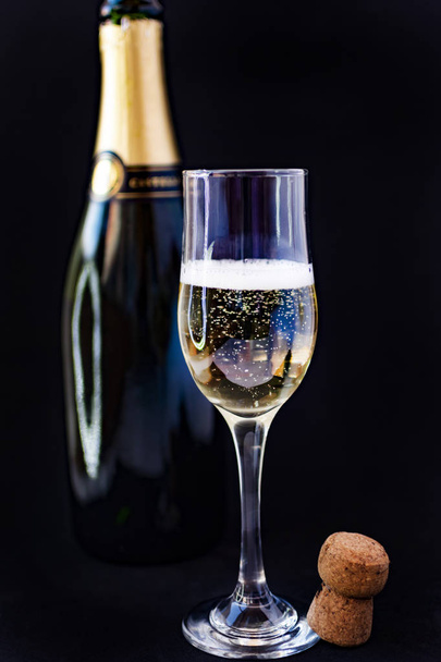Party concept. Cava bottle with black background and two full champagne glasses. - Photo, Image