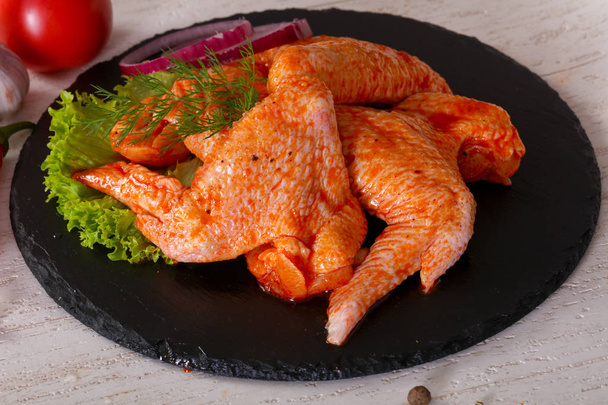 Rauw gemarineerde kippenvleugels voor grill en bbq - Foto, afbeelding