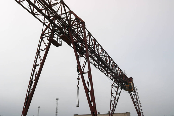 Ipari vas nagy fém Bakdaru egy horoggal szerelve a támogatja az emelési és pakolási nehéz teher, mozog a sínek a gyárban. A daru a híd típusú - Fotó, kép