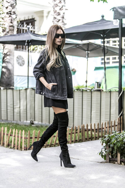 Beautiful young woman wearing fashionable clothes walking on the street - Foto, Imagem
