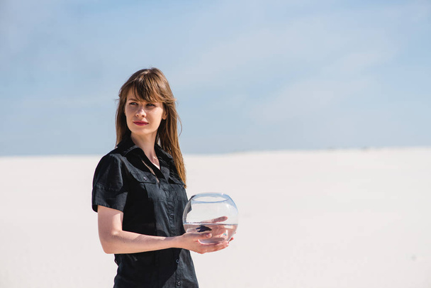 Женщина с аквариумными рыбками в пустыне
 - Фото, изображение