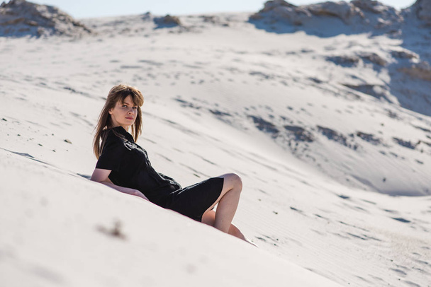 Atractiva joven hembra yacía en las dunas del desierto
 - Foto, imagen