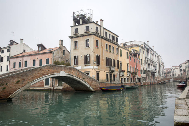 Типовий маленький венетичний романтичний канал у тумані (Венеція, Італія). - Фото, зображення