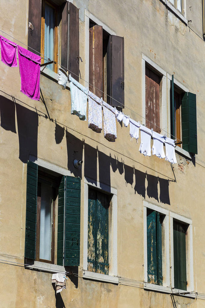 типичный фасад венецианского дома с подвешенным к сухой прачечной
 - Фото, изображение