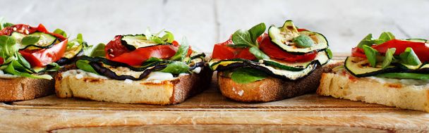 Χορτοφαγικά σάντουιτς με φρέσκο τυρί, ψητά ντομάτες, μελιτζάνες και κολοκυθάκια  - Φωτογραφία, εικόνα