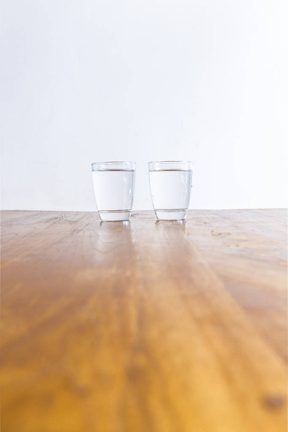 2 full glasses of clear healthy water standing on a wooden table - Photo, Image