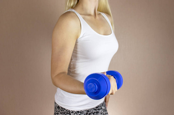 Обрізана жінка в білій сорочці з джеббелем в руці. Схуднення дієта і фітнес концепція
. - Фото, зображення