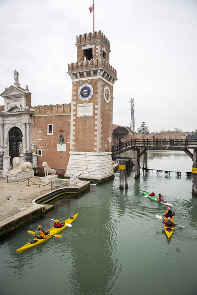 vista dell'Arsenale veneziano con un gruppo di persone su un kayak che remano sul canale, a Venezia
 - Foto, immagini