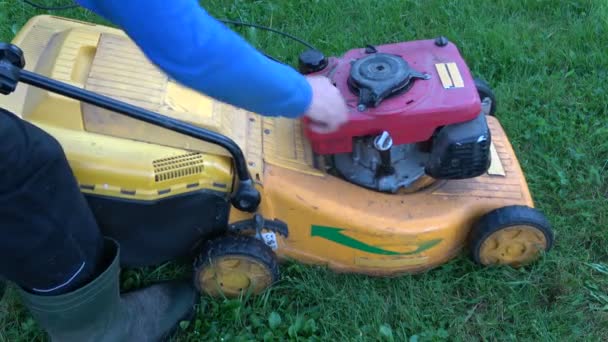 Gardener manually starting old lawn mower and cut grass - Footage, Video