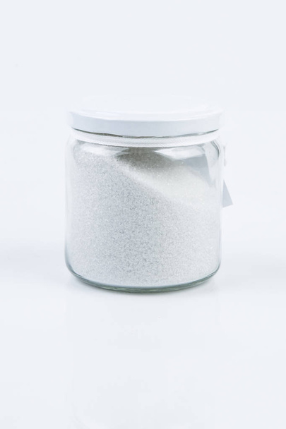 白い背景に分離された塩またはバス塩のガラス瓶 - 写真・画像
