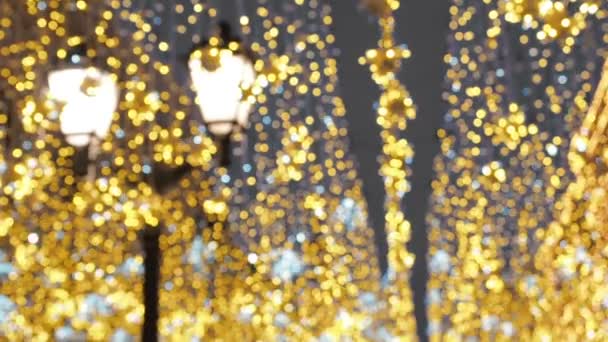 Heldere kerst straat verlichting. De stad is versierd voor de vakantie van de Christmastide. Nieuwjaar lichten versieren glinsterende bokeh - Video