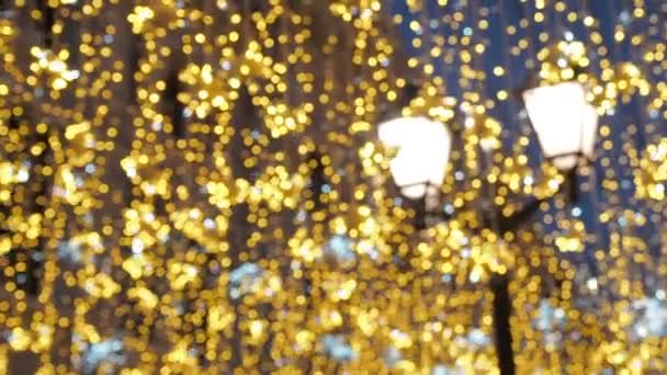 Helle weihnachtliche Straßenbeleuchtung. Die Stadt ist weihnachtlich geschmückt. Silvesterlichter schmücken schimmerndes Bokeh - Filmmaterial, Video