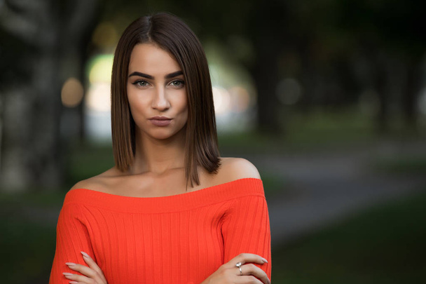 Portrait of confident strict woman in red sweater at the autumn park - Photo, image
