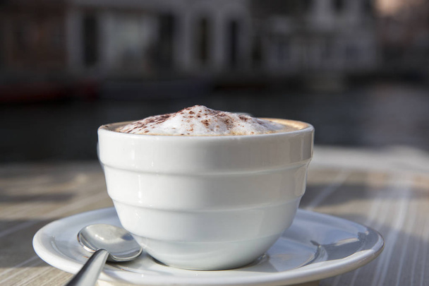 Verse Italiaanse cappuccino op een terrastafel - Foto, afbeelding