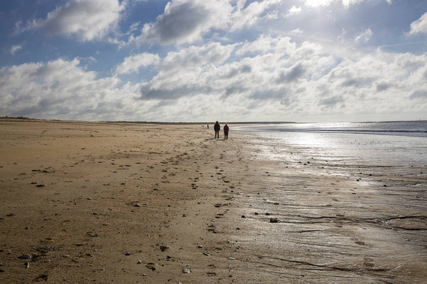 praia de areia em Vendee, França com céu azul e nuvens brancas e pessoas vagando
 - Foto, Imagem