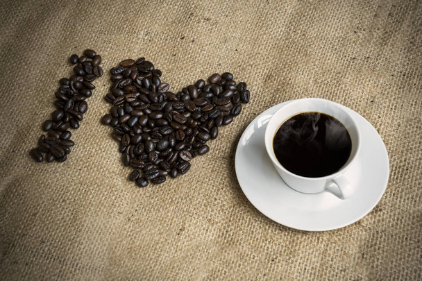 Primer plano de granos de café tostados y taza de café arreglado para formar Me encanta el café
 - Foto, Imagen