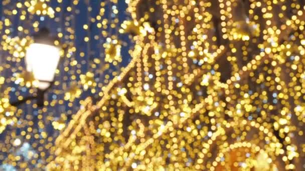 Parlak Noel sokak aydınlatma. Şehrin Noel tatil için dekore edilmiştir. Yeni yıl ışık dekorasyon parıldayan bokeh - Video, Çekim