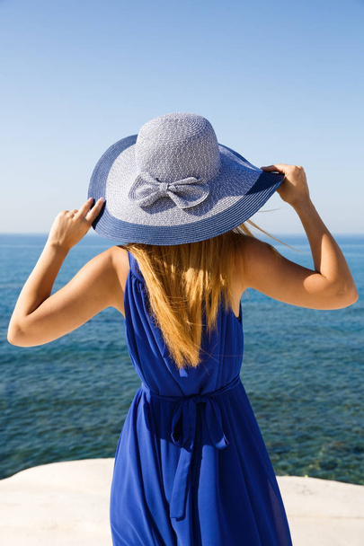 Pretty blond woman in the blue dress at the beach in Cyprus. - Фото, зображення