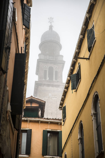 narrow street with bell tower - campanile - of San Pantalon in the mist, Venice , Italy - Photo, Image