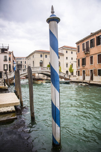 Romantyczny kanał z zieloną turkusową wodą i białym i niebieskim paskiem w paski, Wenecja, Włochy - Zdjęcie, obraz