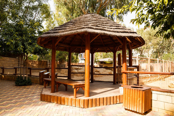 Pabellón redondo de madera con banco en el parque
. - Foto, imagen