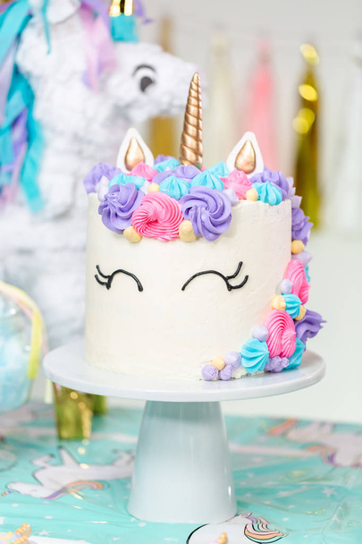 Mesa de fiesta de cumpleaños de niña pequeña con pastel de unicornio, cupcakes y galletas sugaer
. - Foto, Imagen