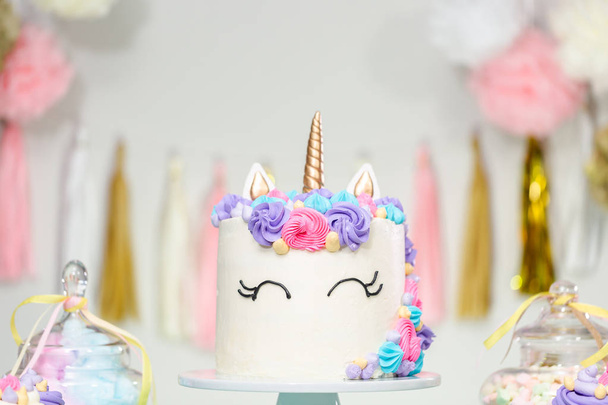 Little girl birthday party table with unicorn cake, cupcakes, and sugaer cookies. - Photo, image