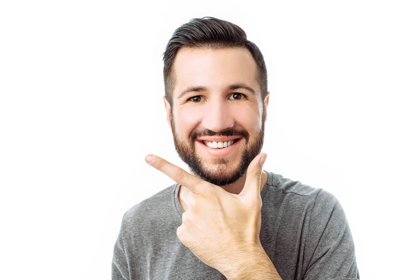Happy young hipster wearing grey shirt shows emotions of happiness and joy, man on white background - Fotografie, Obrázek