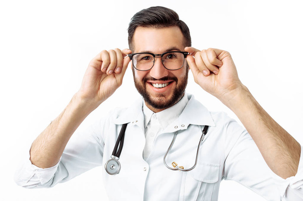 Portrait of a young hipster doctor, on a white background, Intern in the Studio, with a stethoscope on the neck - Photo, Image