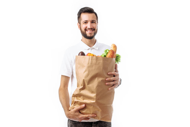 Young handsome hipster man holding a bag of food isolated on white background, advertising, text insertion - Фото, зображення