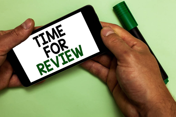 Writing note showing Time For Review. Business photo showcasing Evaluation Feedback Moment Performance Rate Assess Human hand hold iPhone with texts touched green marker. - Photo, Image