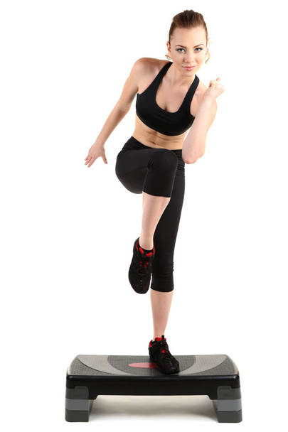 Young woman doing fitness exercises on stepper isolated on white - Valokuva, kuva