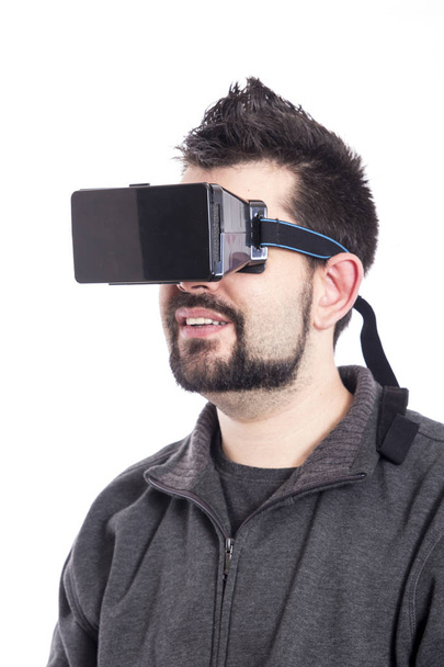 man wearing virtual reality goggles and standing in white studio  - Фото, зображення