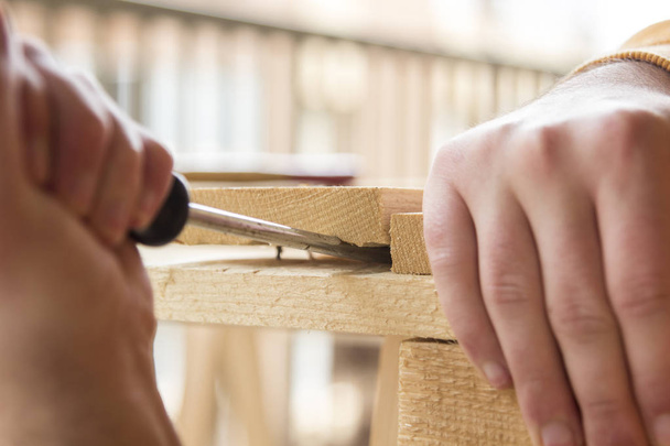 Nahaufnahme eines männlichen Tischlers, der in der Tischlerei mit Holz arbeitet - Foto, Bild