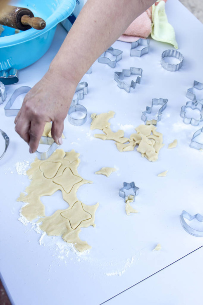 person preparing Christmas ginger cookies with Aluminium Christmas Cookie Cutters - Valokuva, kuva