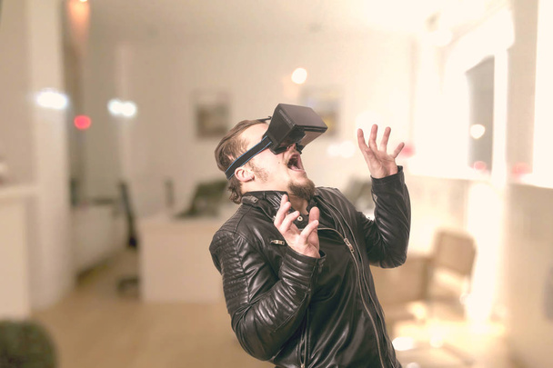 shocked man wearing VR glasses and playing in virtual reality simulation at home - Valokuva, kuva