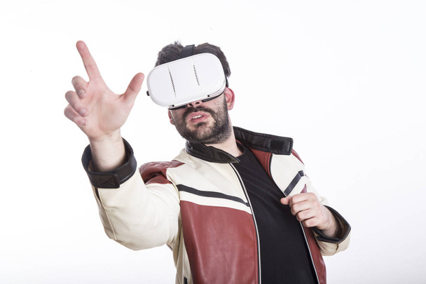 man wearing virtual reality goggles in white studio and wearing stylish leather jacket  - Fotó, kép