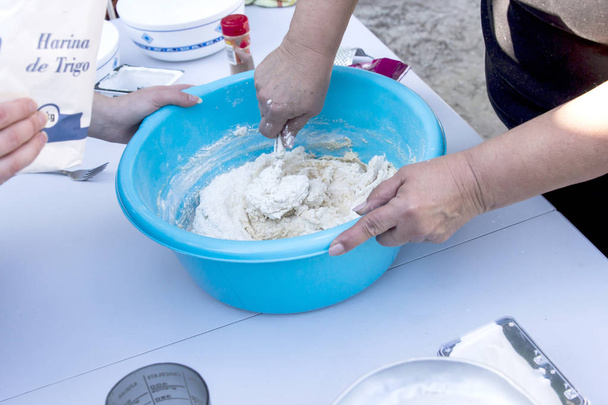 people preparing dough in blue washbowl - Valokuva, kuva