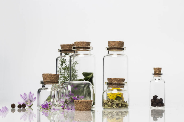 Transparency glass bottles with dry flowers, isolated on white  - Foto, afbeelding