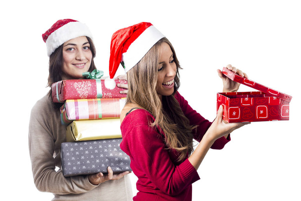 smiling two women posing in studio at Christmas new year time, holding gift boxes  - Foto, Bild