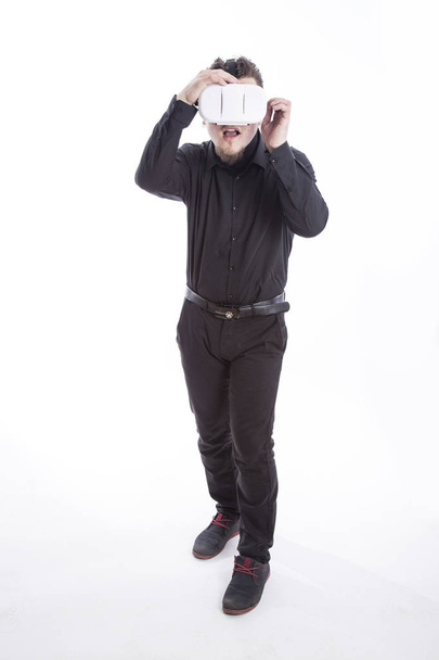 full length of shocked man with opened mouth wearing VR glasses in studio  - Foto, Imagem