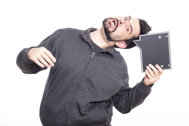 funny playful Caucasian man holding grey speech bubble board for copy space - 写真・画像