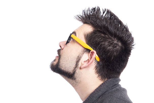 portrait of man wearing yellow glasses in studio and looking up  - Photo, image